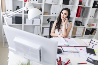 Charming young brunette girl with glasses working in the office. photo with depth of field