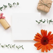 Empty memo paper with flower and gift on white background. flat lay, top view, copy space