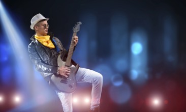 Young man rock musician in lights of stage