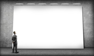Rear view of businessman in concrete room looking at blank banner