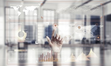 Hand of woman working with media interface on screen and office interior at background