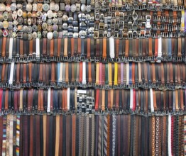 Many colored leather belts on a market