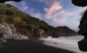 Silhouette frame of a beach cave and view Marina di Maratea Beach at sunset
