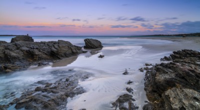 Colorful sunset over the picturesque white sand beach and turquoise waters at La Pelosa Beach