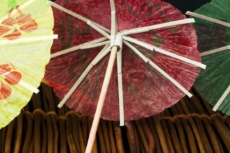Colorful cocktail umbrellas on wooden base. Close up