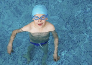 Little boy in swimming pool. Blue swimming pool