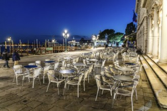 Restaurant tables on the promenade, evening mood at blue hour, Venice, Italy