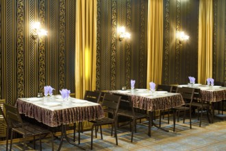 Served tables in a cafe, black and golden hues