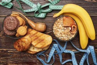 Measuring tapes, fruits and sweets. Struggle to get healthy