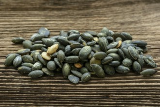 Pumpkin seeds seasoned using sea salt. Pumpkin seeds over wooden table