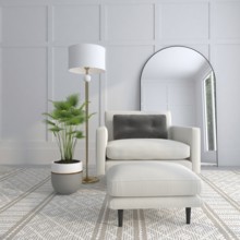 A cozy modern room with an armchair, floor lamp, potted plant, and mirror