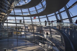 The shimmering Reichstag dome shines in all its splendour as visitors explore the modern interior.