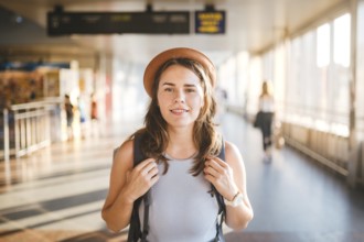 Theme tourism travel. Young beautiful Caucasian woman in dress and hat with backpack tourist mat in