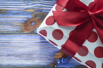 Red boxed birthday gift on vintage wooden board