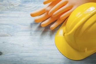 Set of insulating gloves hard hat on wooden board electricity concept