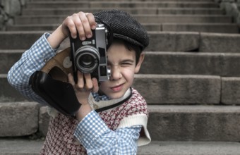 Child with vintage camera. Exterior stairs