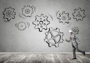 Young handsome businessman wearing white paper crown running and gear mechanism on wall