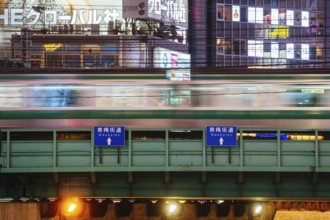Shinjuku, Japan, 18 May 2019: Neon signs illuminate Tokyo?s busy Shinjuku neighborhood with bridge