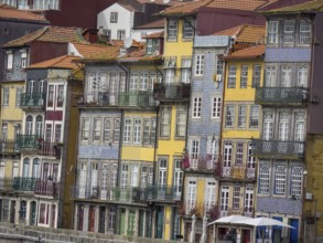 Row of multi-storey, colourful houses with ornate balconies and historic charm, porto, portugal