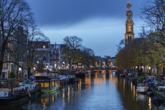 Evening atmosphere with canals, bridge and a tower in the distance, Amsterdam, Netherlands