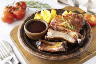 BBQ grilled veal calf brisket meat and french fries potatoes with sauce on a marble tabletop