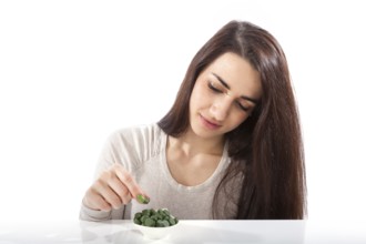 Beautiful happy healthy girl in her 20s with green dietary supplements chlorella, spirulina and