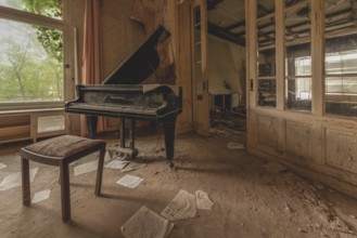 Abandoned room with a piano, sheets of paper on the floor and old walls, lost place, urologist's