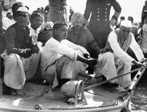Jawaharlal Nehru Devdas Gandhi and Ramdas Gandhi holding the urn on boat to confluence of rivers