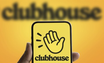 Clubhouse logo is displayed on smartphone. Clubhouse is a social audio app for iOS and Android.