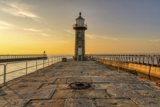 Golden Hour at the East Pier and Whitby East Harbour Lighthouse in Whitby, North Yorkshire,