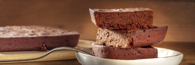 Chocolate brownie panorama, simple coffee cake, a side view shot on a dark rustic wooden