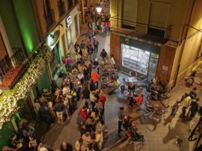 People of all ages enjoy a a party on the Torres de Omana Square on a mild autumn evening, Leon,