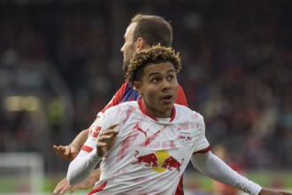 Football match, Antonio NUSA RB Leipzig in front looks up during the aerial fight with Benedikt