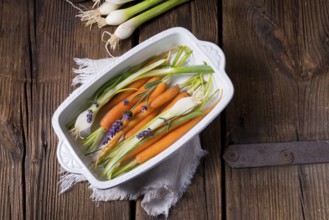Young carrots and spring onions prepared for baking