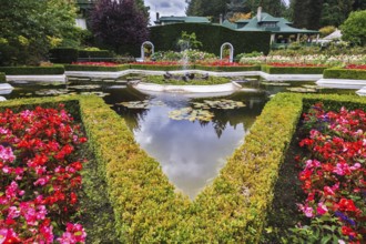 Exquisite fountain among the flower beds. Delightful landscaped and floral park Butchart Gardens on