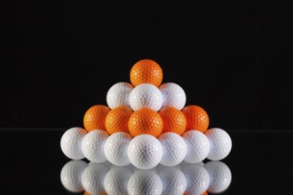 Pyramid of golf balls on a black background