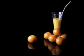 Orange juice and mandarins on black