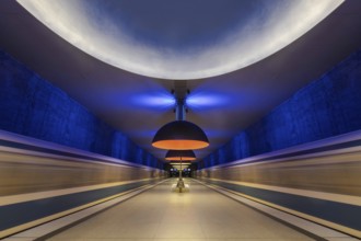Futuristic underground railway tunnel with blue and yellow lighting, Munich, Bavaria, Germany
