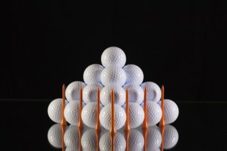 Pyramid of golf balls on a black background