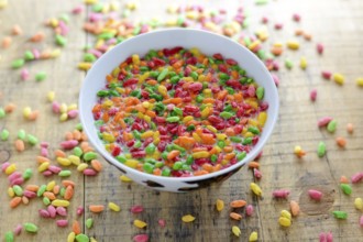 Prepared breakfast with milk and colorful puffed rice in the bowl with spilled rice in the