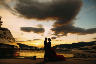 Couple hugging each other at sunset on a boat pier.