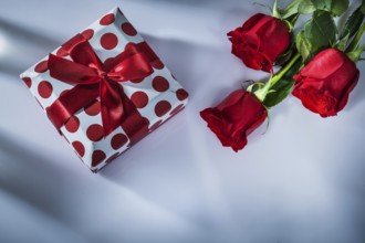Gift box red roses on white background