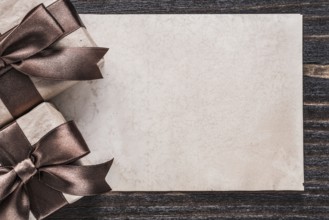 Wrapped boxed gifts paper on vintage wooden board holiday concept