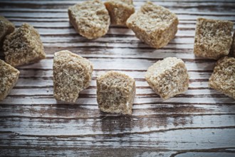 Vintage cane sugar cubes on wooden board top view