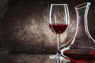 Very close up decanter and wineglass with red wine on vintage wooden background