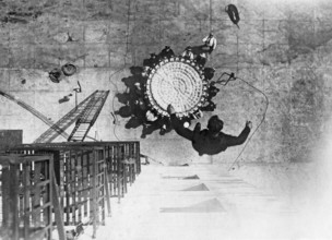 In the 1930s. A man jumps from a building into a life saving sheet. A device invented in 1887, and
