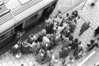 Bus stop in Stockholm in 1953. People are waiting for the bus at the bus stop. Bus 32 travelling on