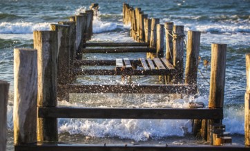 Waves crashing against the pillars of a jetty