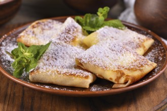 Thin pancakes filled with cottage cheese, honey and raisins, wrapped in an envelope, sprinkled with
