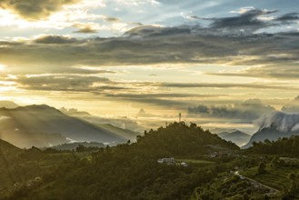 Mountains under the light of sunrise through clouds